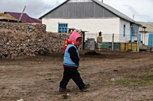 Un bambino del villaggio di Sary Tash, Kyrgyzstan, cammina tra il vento gelido verso la propria abitazione