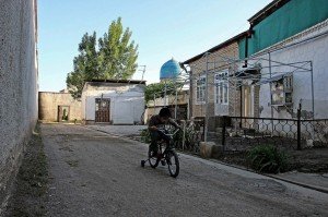 Un bambino gioca nella zona popolare chiusa da mura, vicino piazza Registan, Uzbekistan