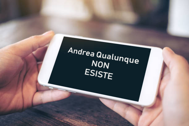 Cellulare tenuto da due mani con la scritta Andrea Qualunque non esiste